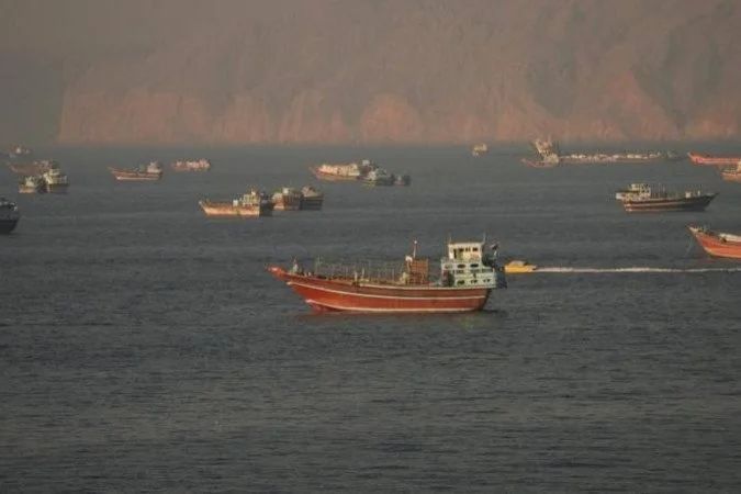Navio mercante e escolta naval no estreito de Ormuz