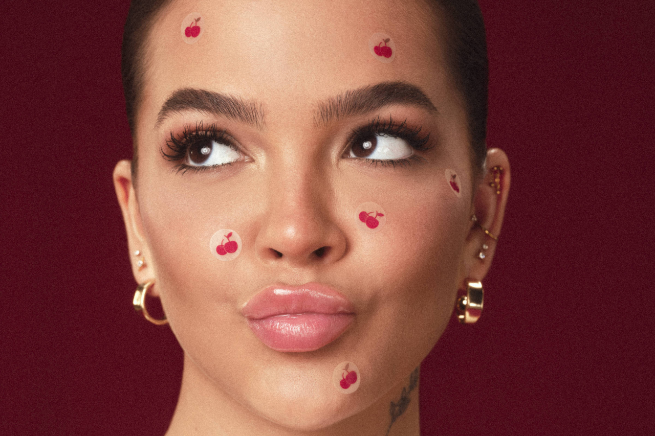 Adesivos coloridos para espinhas aplicados no rosto