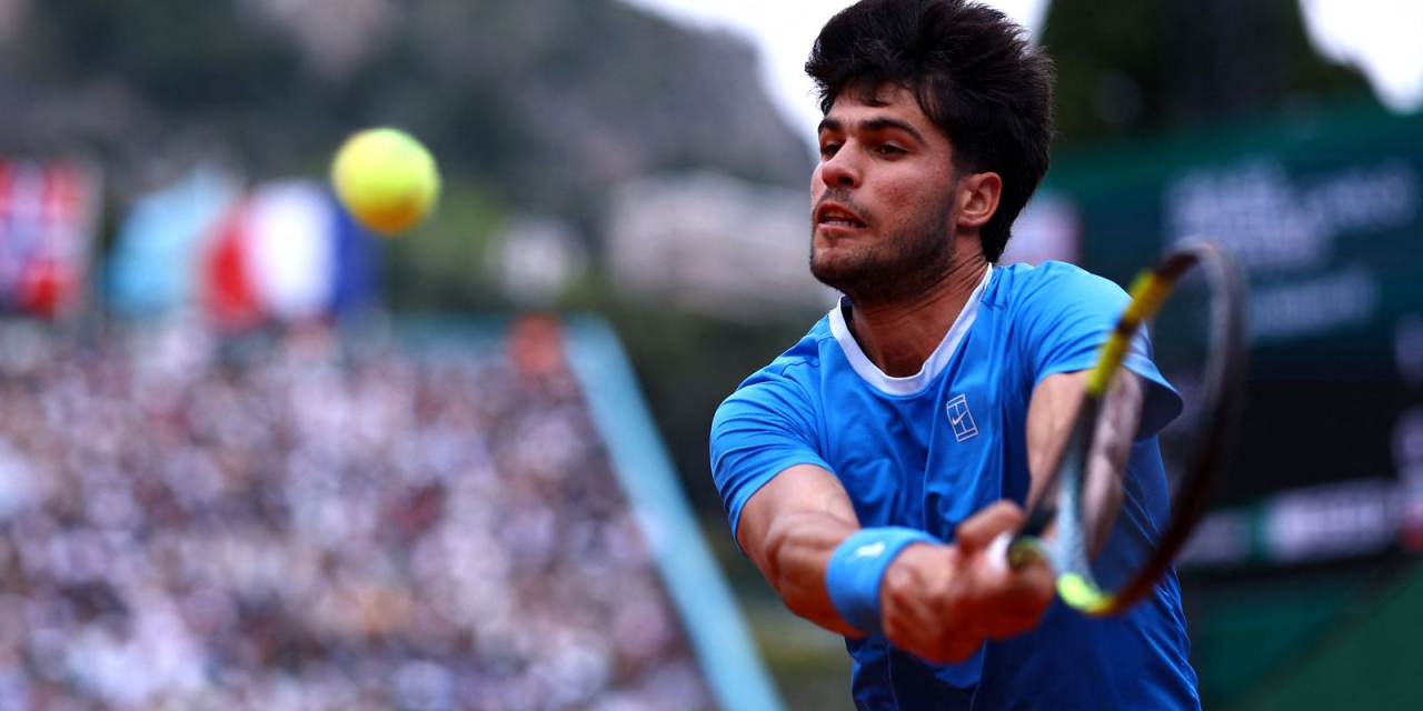 Carlos Alcaraz em quadra segurando o punho