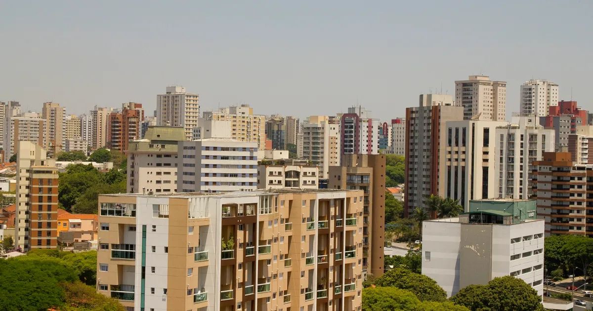Prédios residenciais com placa de aluga-se em rua da cidade