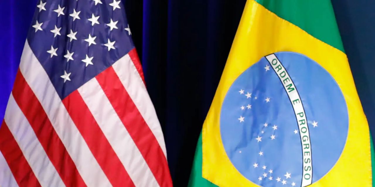 Bandeiras do Brasil e dos Estados Unidos sobre mesa de negociação