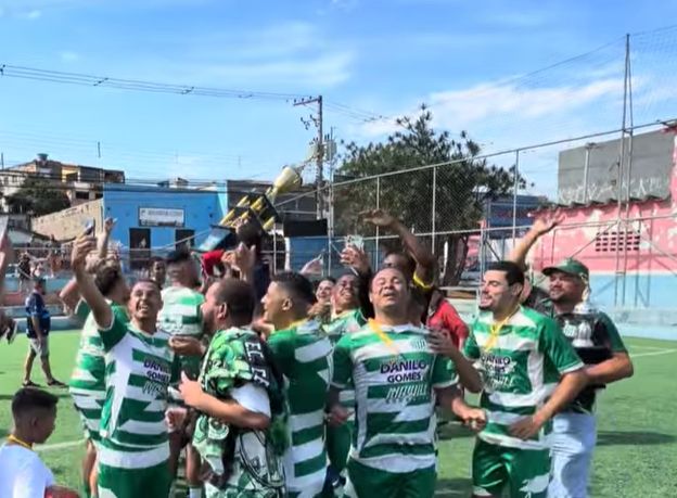 Jogadores do Cabuçu comemorando o título com a taça