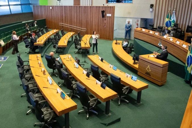 Eleitores e painel com nomes de candidatos