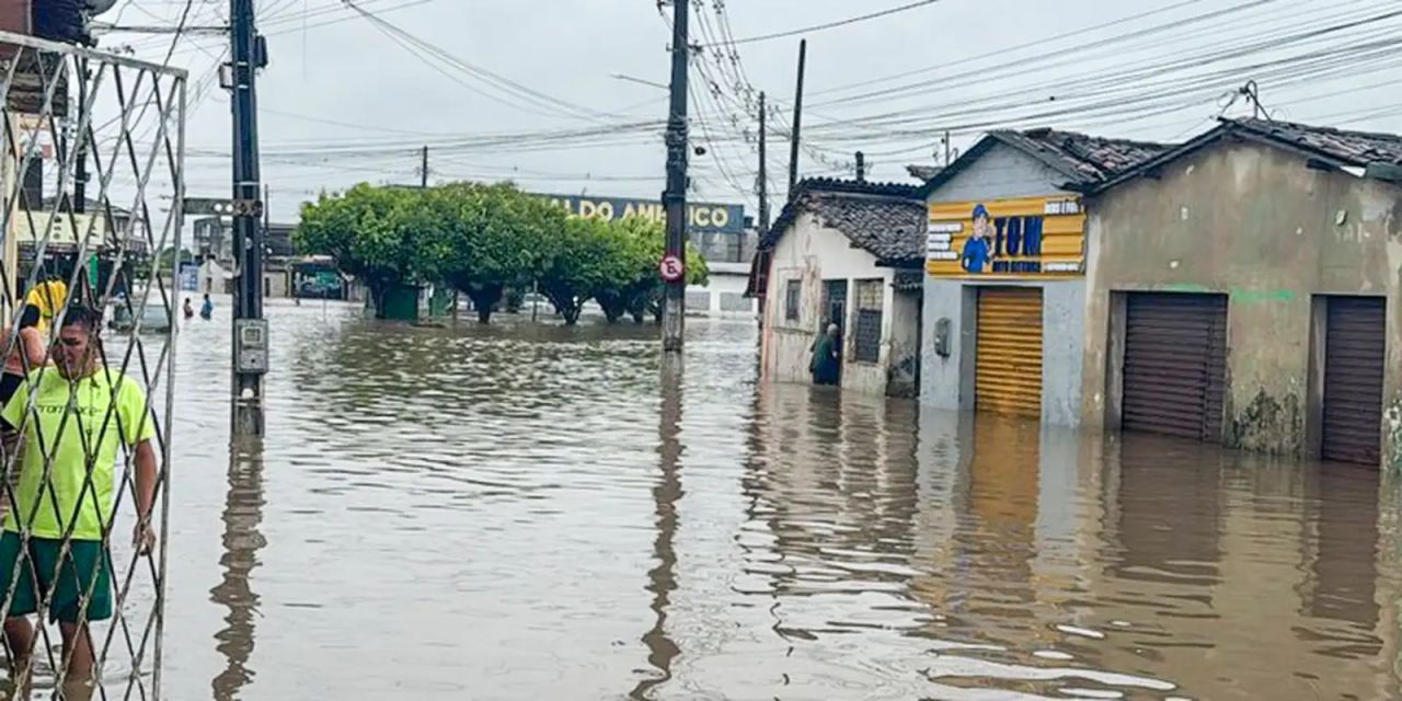 Equipes de resgate em rua alagada na Paraíba