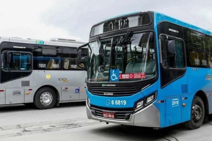 Eleitores aguardam ônibus em fila para chegar às seções eleitorais