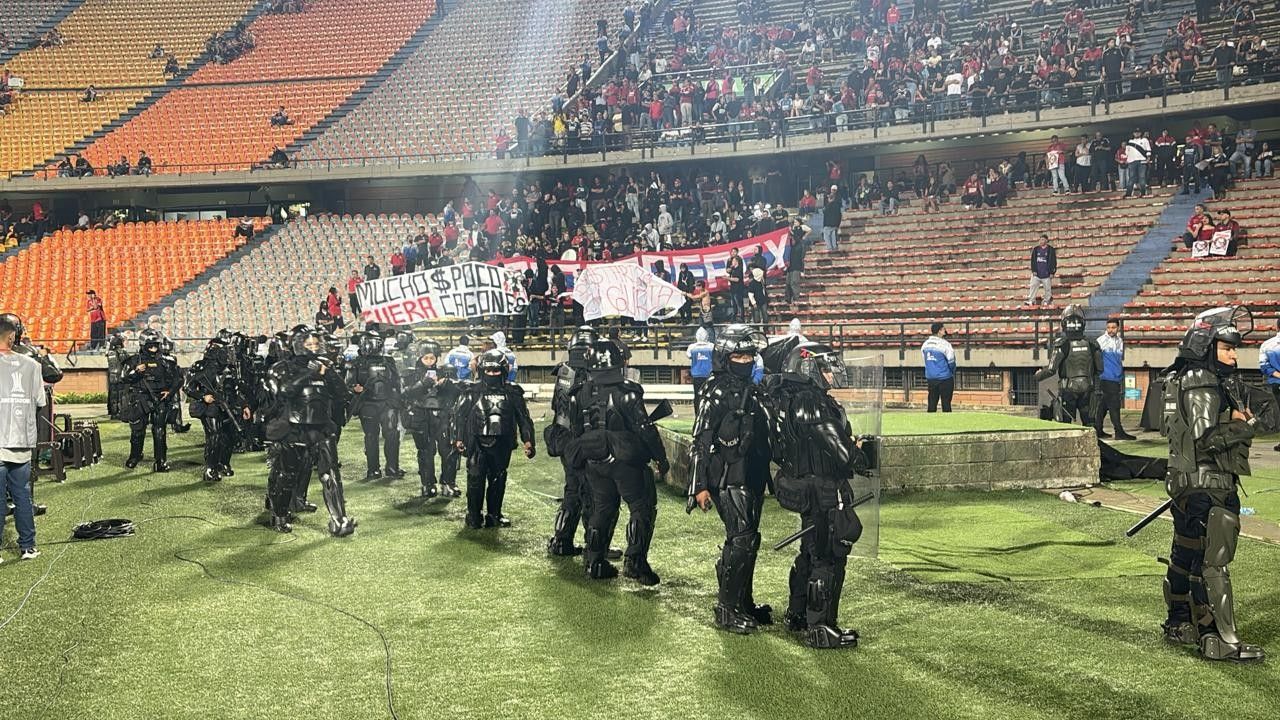 polícia e seguranças no gramado após invasão em Medellín
