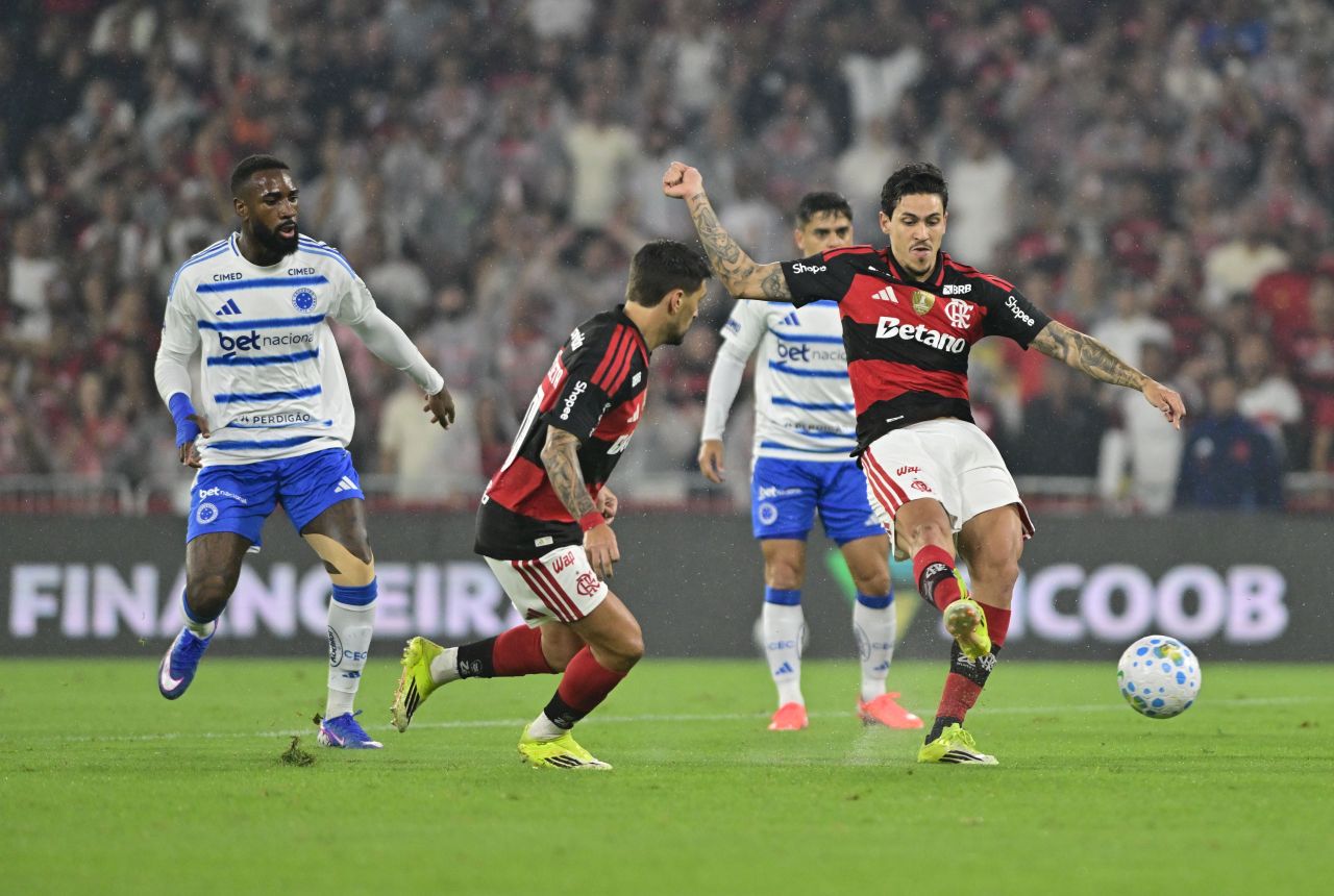 Jogadores de Cruzeiro e Flamengo disputando bola em campo
