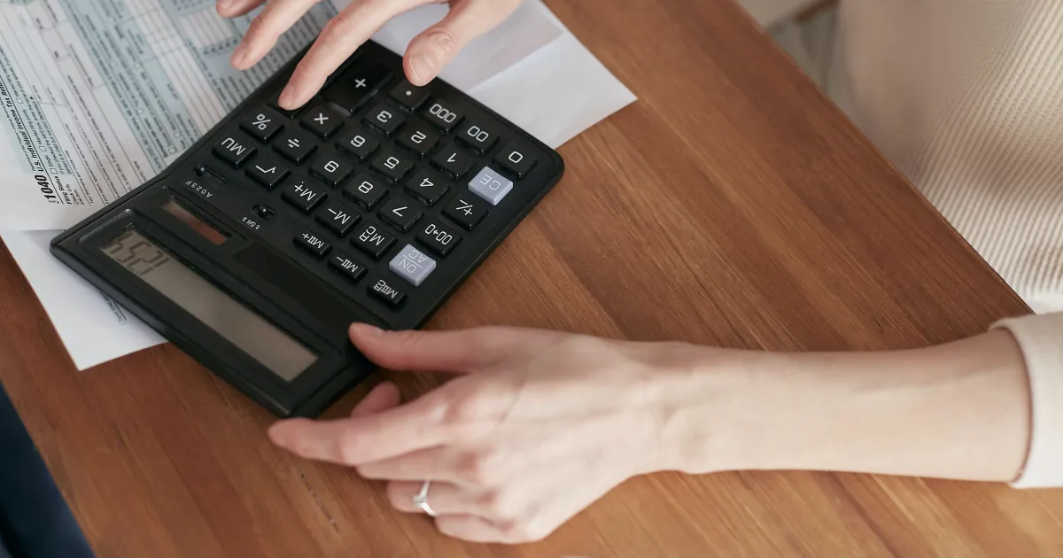 Pessoas conferindo contas e notas sobre mesa