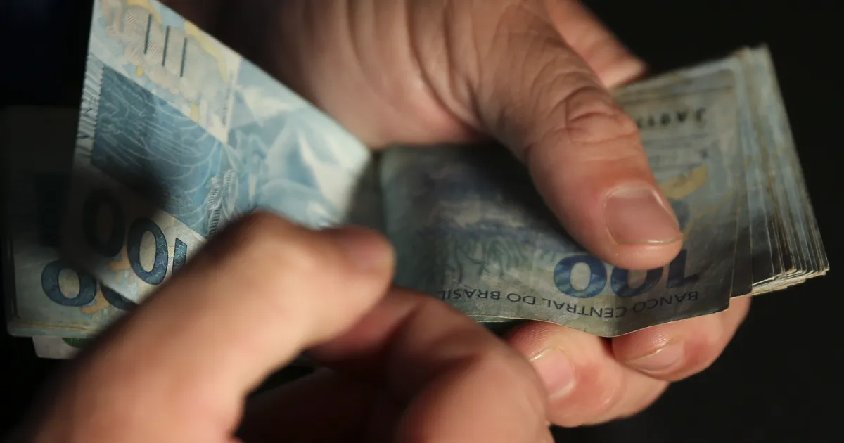 ministro anunciando medida econômica diante de microfone