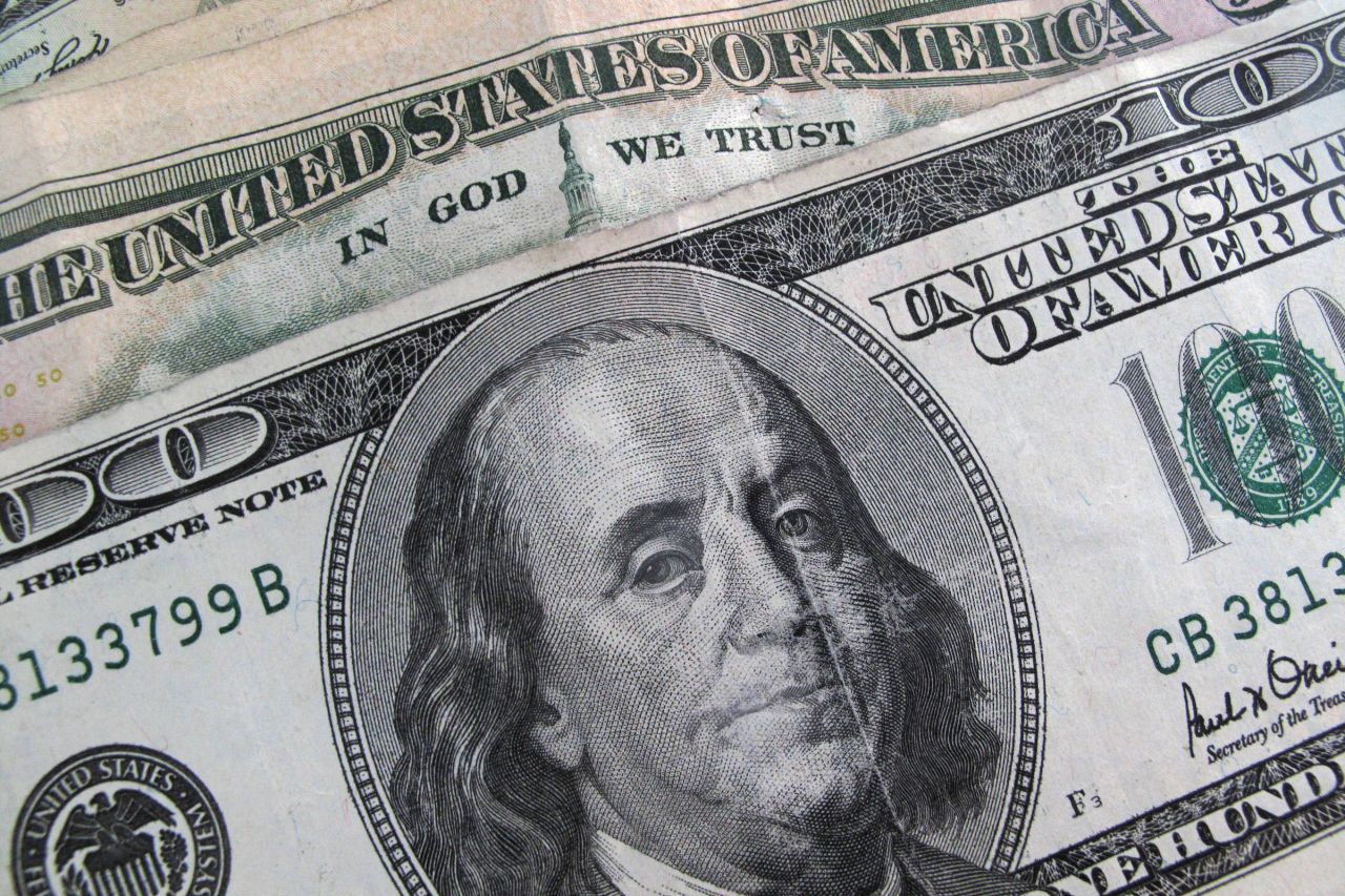 Painel da Bolsa e cédulas de dólar