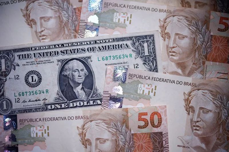 Painel eletrônico mostrando cotações do dólar em ambiente de pregão