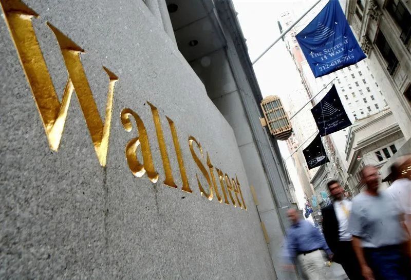 Painel eletrônico em Wall Street mostrando índices em alta e baixa