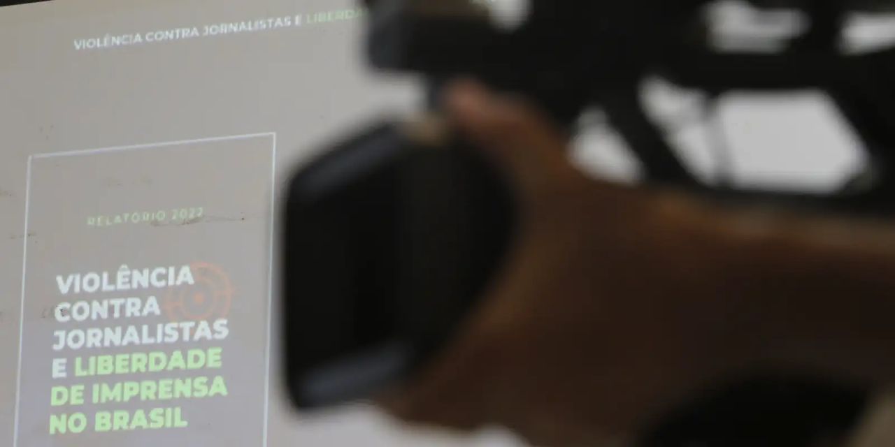Redação de jornal com computadores e jornais sobre a mesa