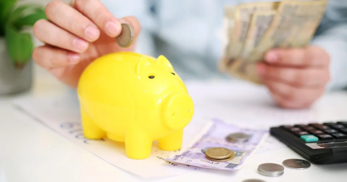 Mãos segurando calculadora e cadernos de controle financeiro