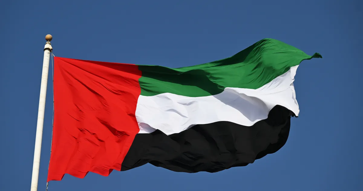 Bandeiras dos Emirados Árabes Unidos em frente a edifício oficial