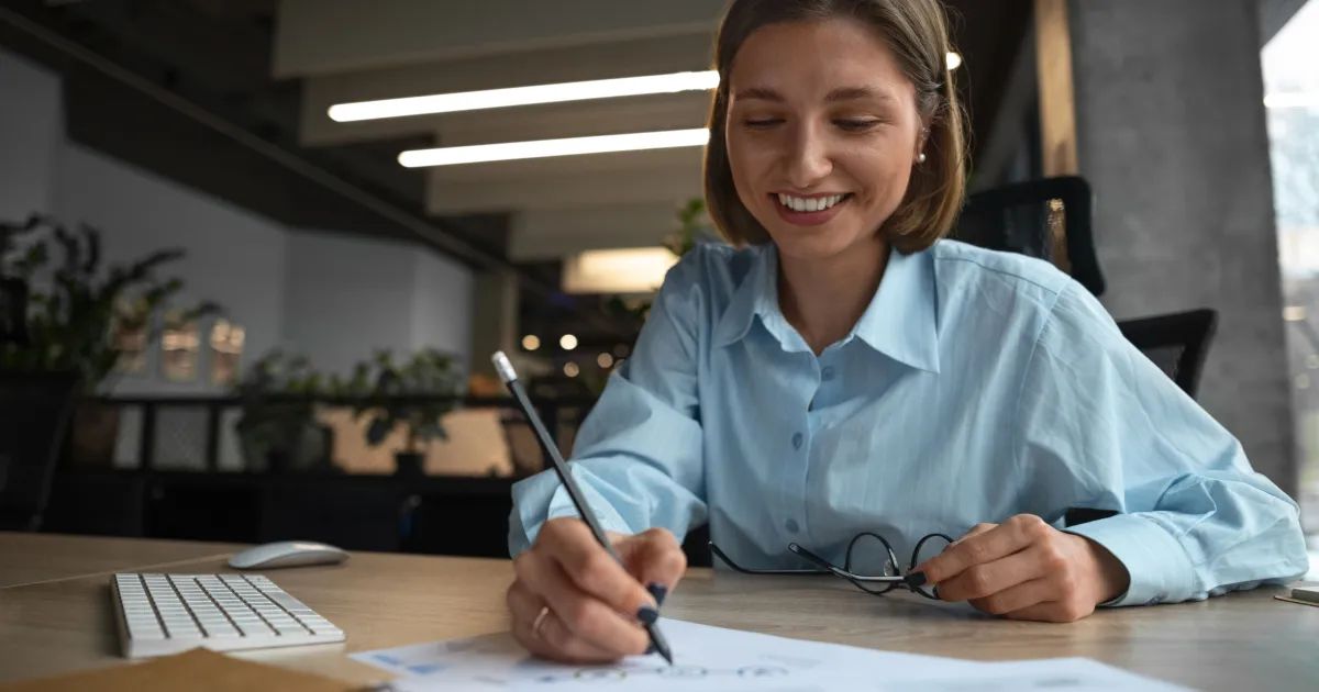 Pessoa gerindo orçamento doméstico em mesa com contas e celular