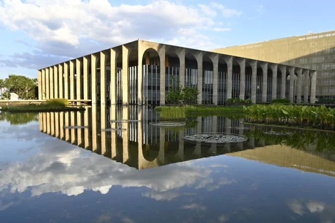 Bandeiras do Brasil e Estados Unidos em frente a edifício diplomático
