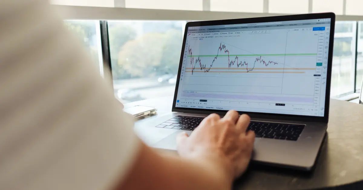 Tela com gráfico de mercado e investidores consultando dados