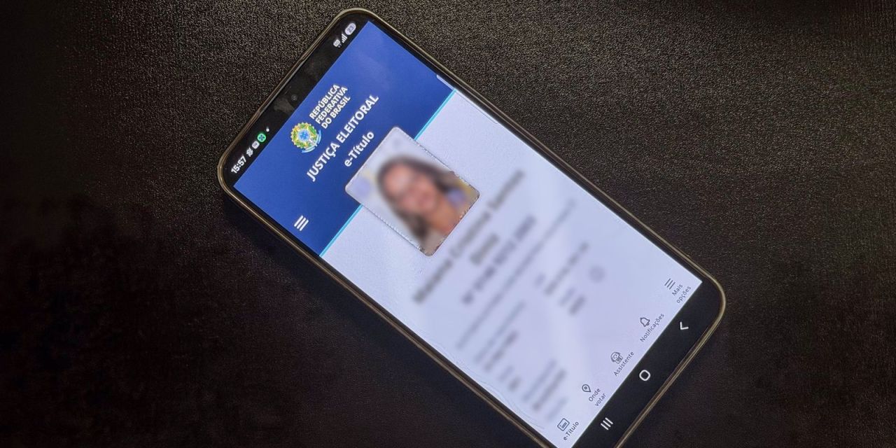 Pessoa usando celular com o aplicativo e-Título aberto