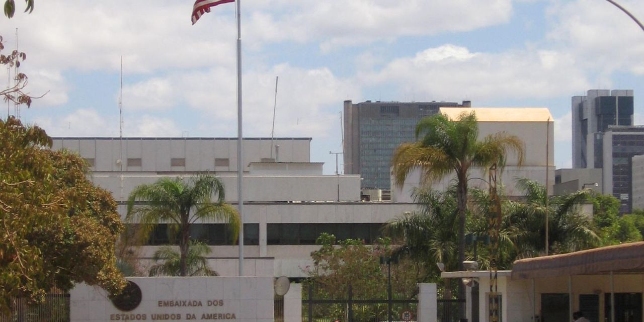 Fachada da embaixada com bandeira americana à frente