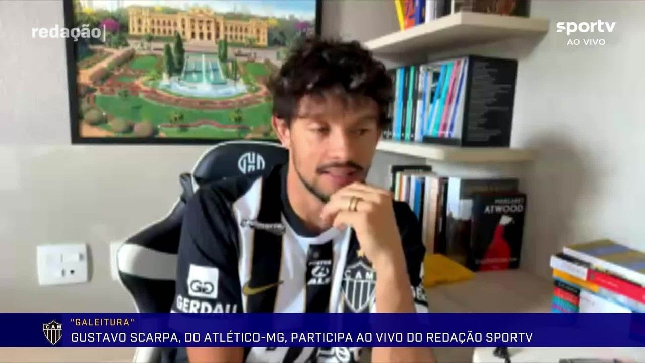 Gustavo Scarpa com a camisa do Atlético-MG segurando livros