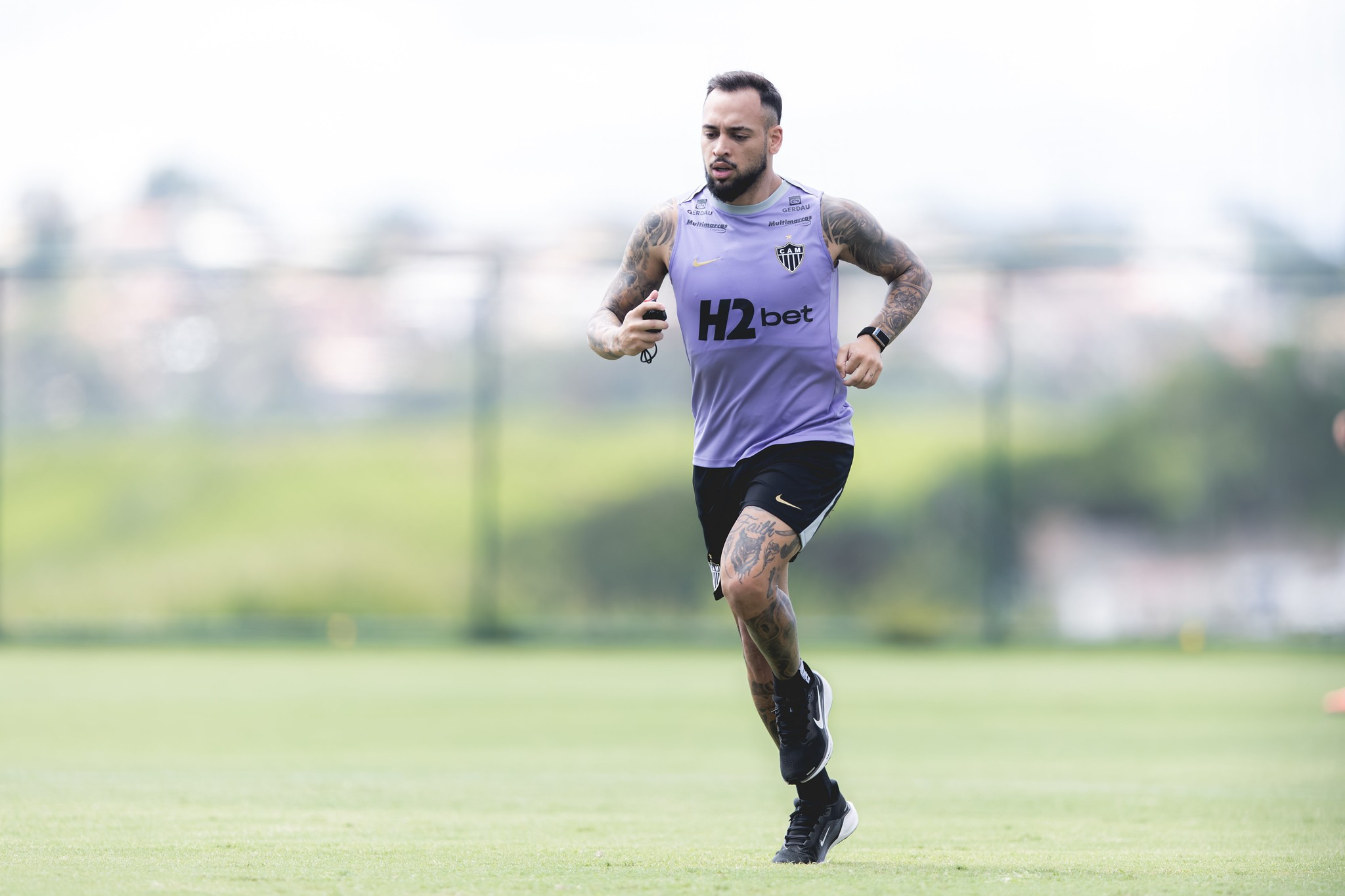 Maycon correndo no gramado da Cidade do Galo durante treino