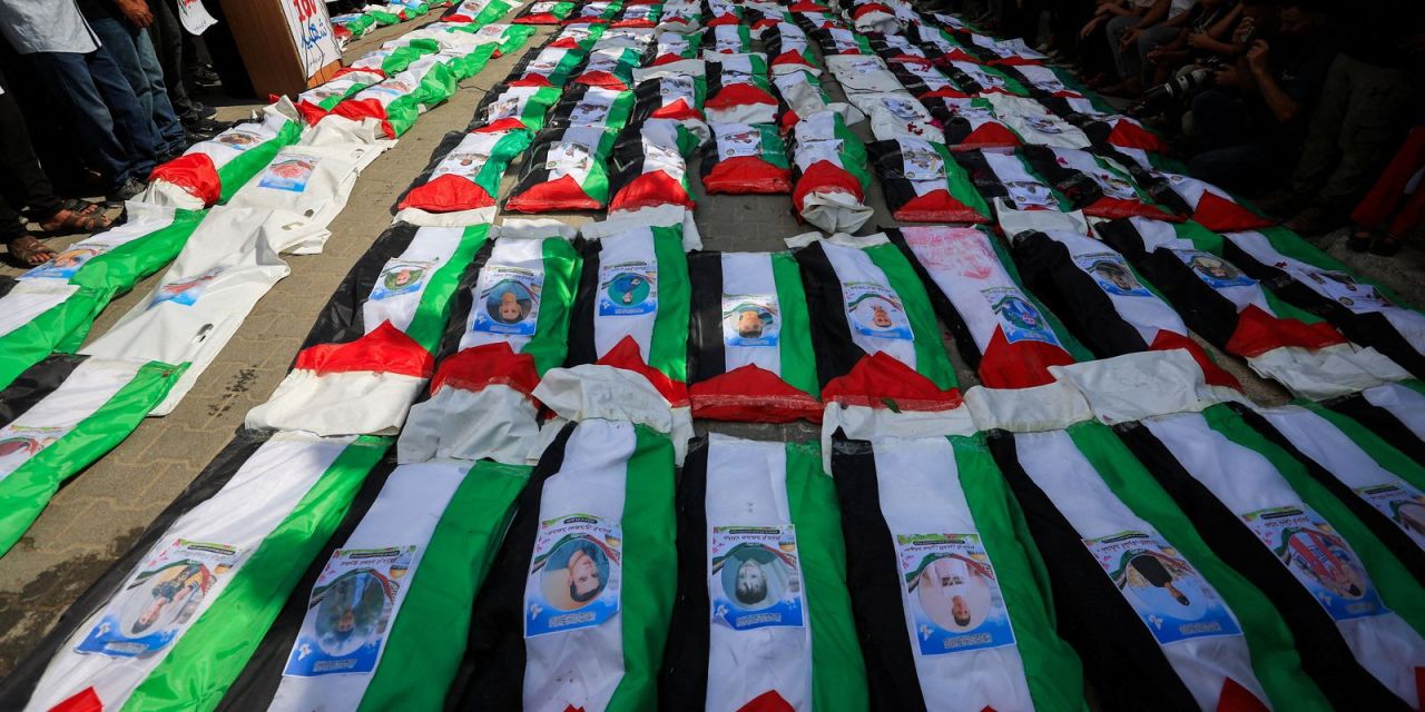 Enterro em Gaza de 100 pessoas com caixões cobertos por bandeiras palestinas