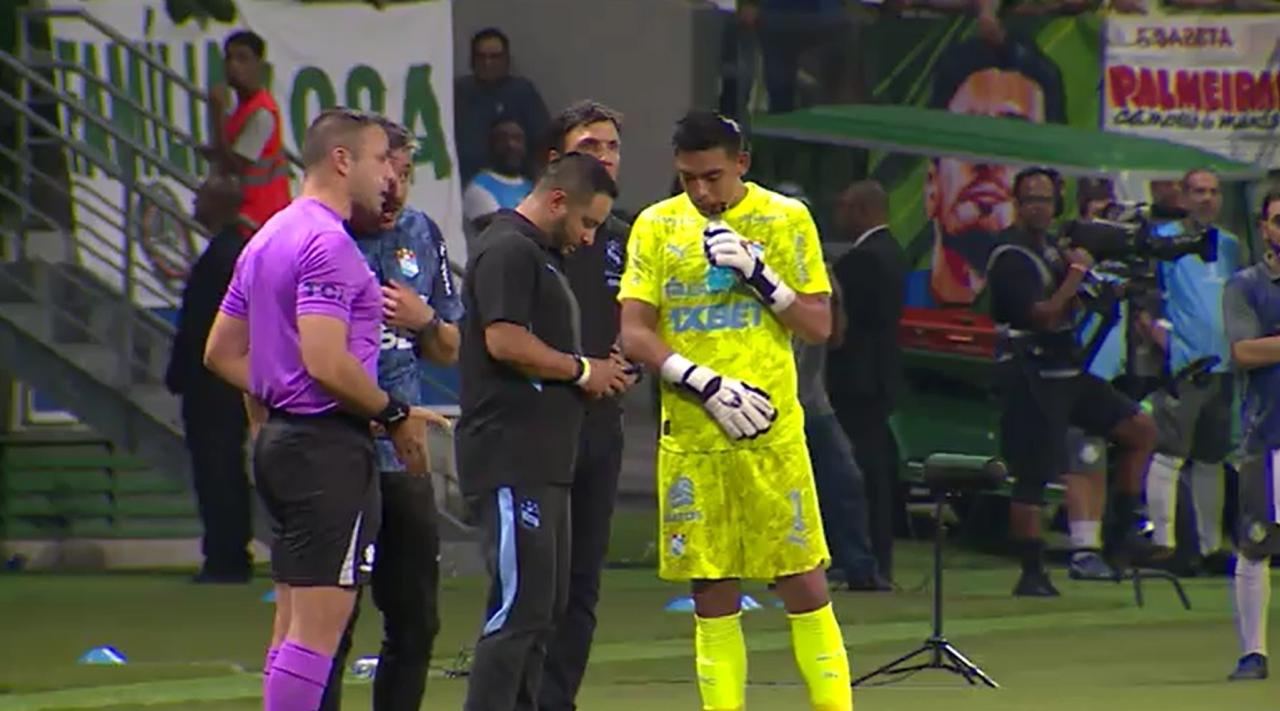 Goleiro do Sporting Cristal olhando celular na beirada do campo