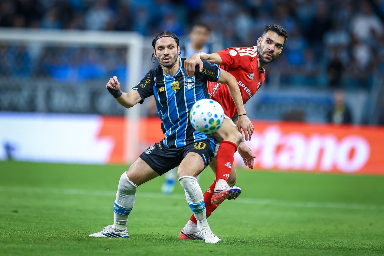 Jogadores do Inter e do Grêmio disputam bola em clássico no gramado