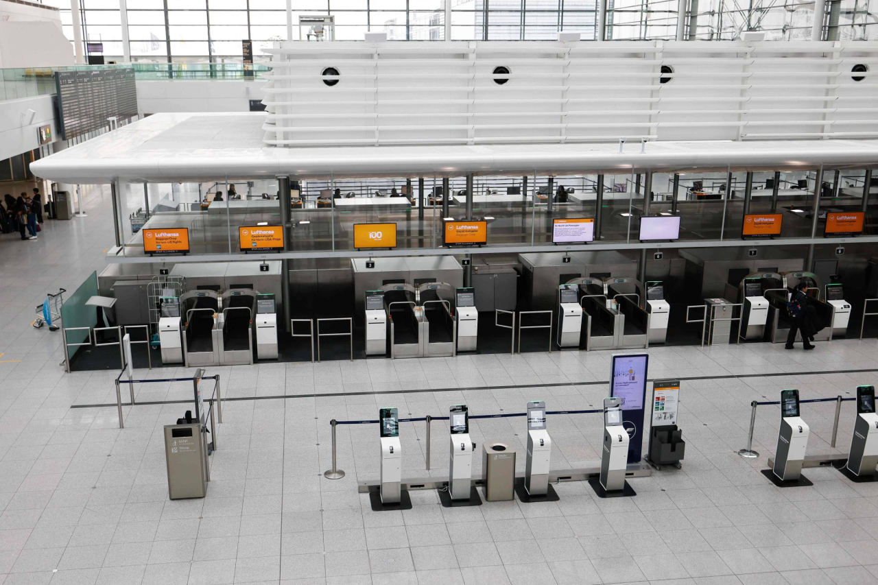 Terminal do aeroporto de Frankfurt com filas e painéis de voos
