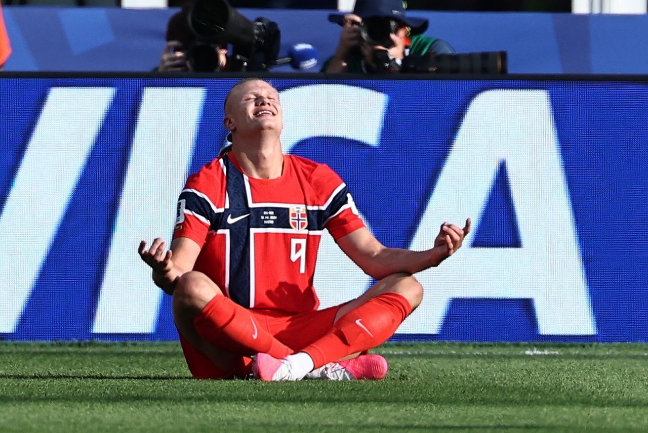 Erling Haaland sentado simulando meditação após gol