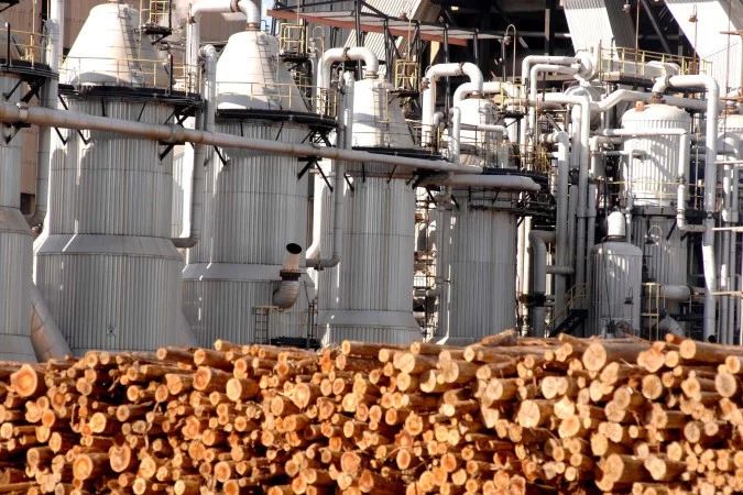 Área industrial com chaminés e estruturas metálicas