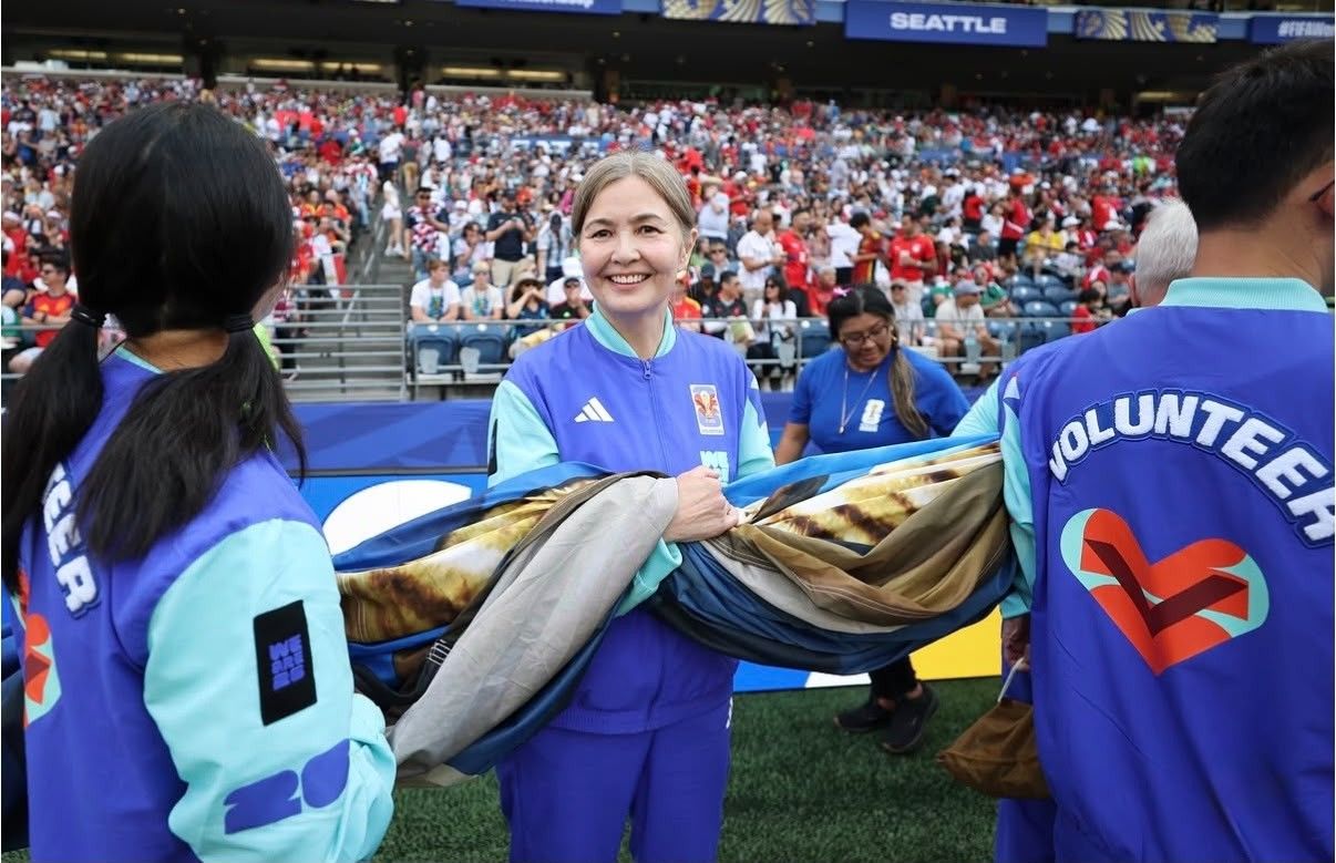 Voluntários segurando bandeiras durante cerimônia da FIFA