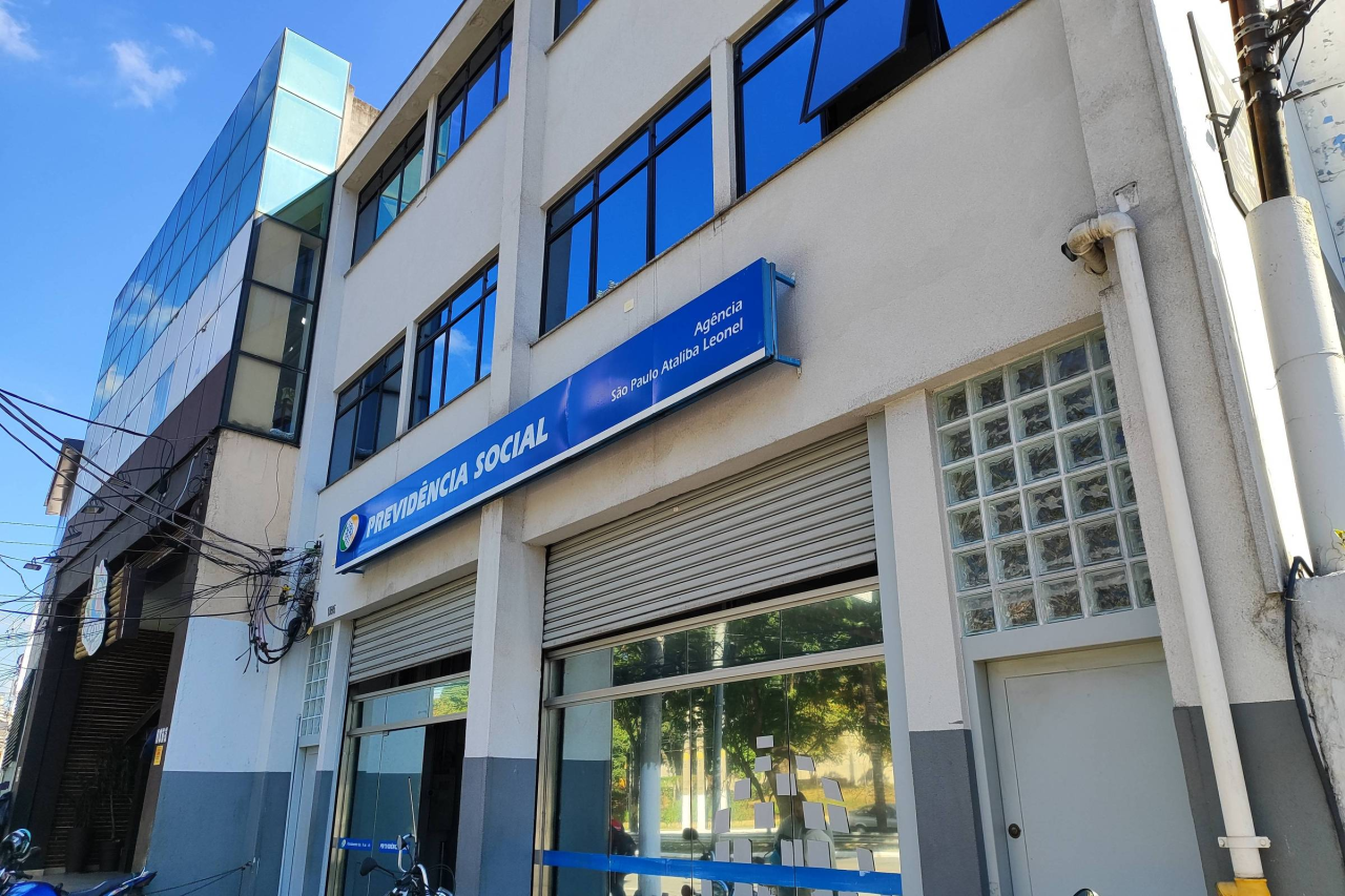 Cartão do INSS e cédulas representando pagamento