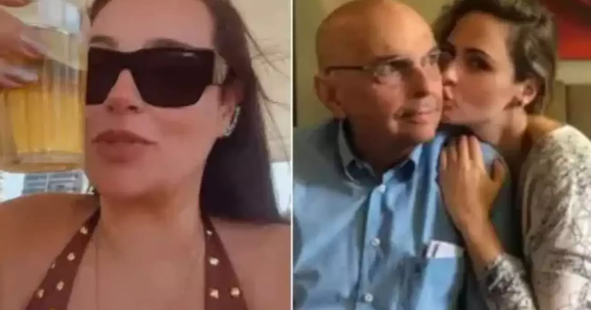 Cida Renault sorrindo com copo na mão em quiosque na praia