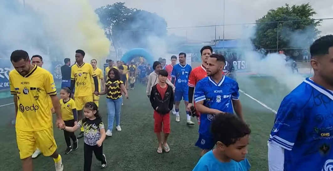 Jogadores do Jacarezinho comemoram o título da Copa das Comunidades em Ferraz de Vasconcelos, com Renan em destaque após marcar o gol decisivo de pênalti.