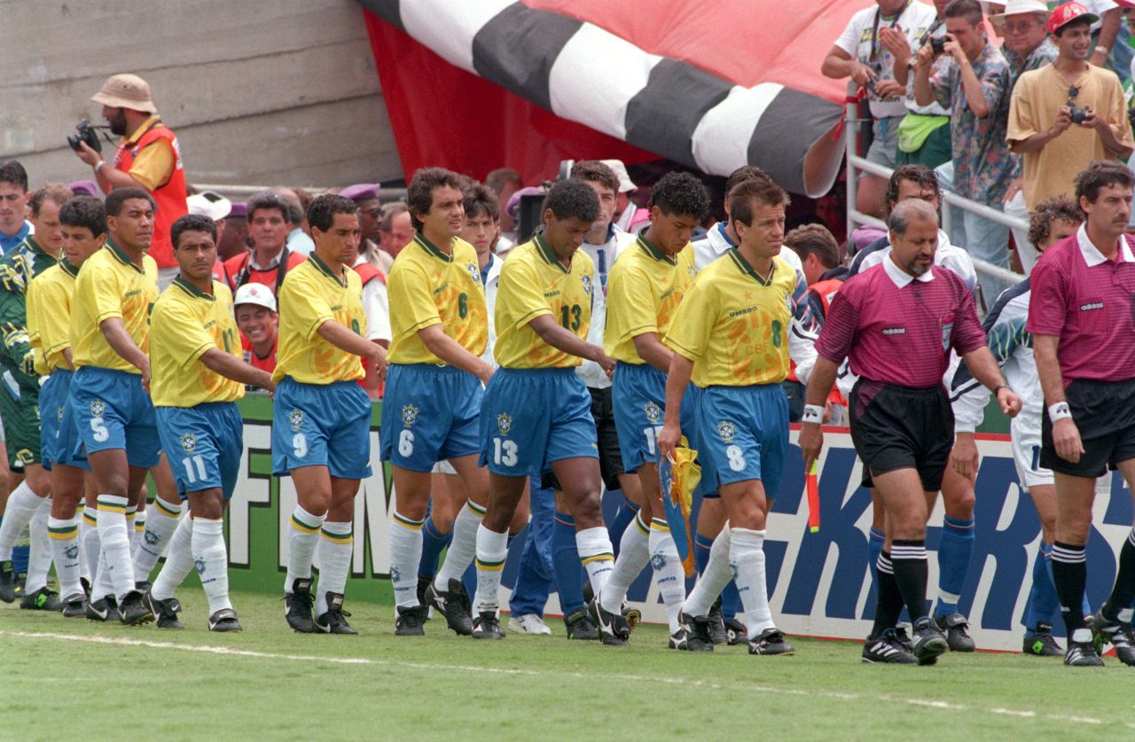 Jogadores da seleção brasileira entrando de mãos dadas