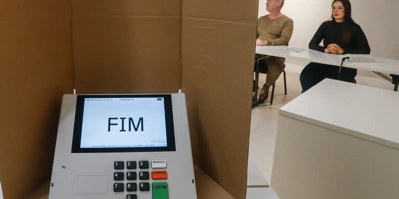 Eleitor entrega celular à mesa receptora