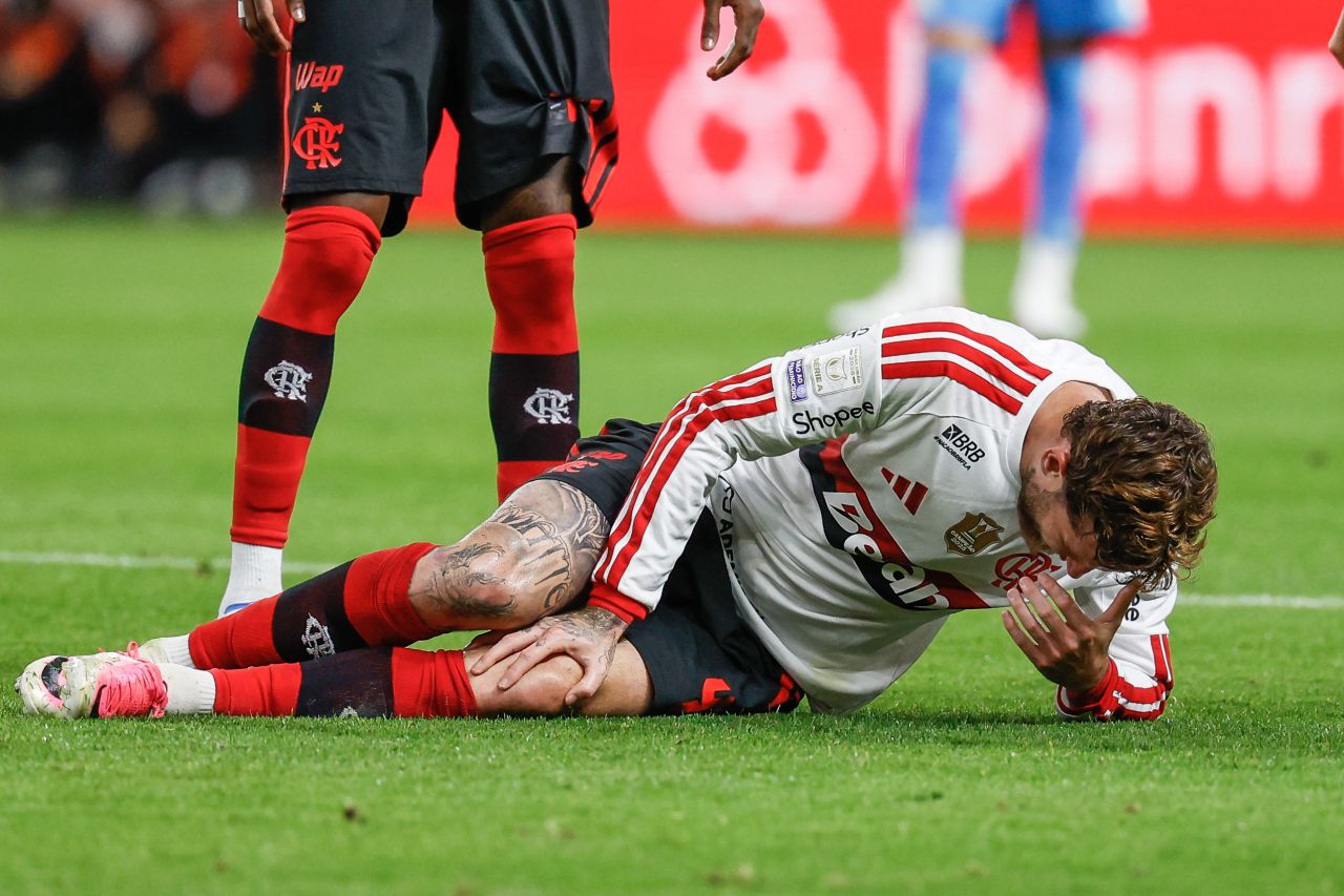 Léo Pereira com a mão no joelho esquerdo durante jogo