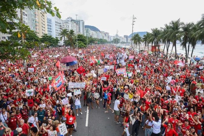 Manifestantes com bandeiras vermelhas ocupam a Avenida Atlântica em Copacabana