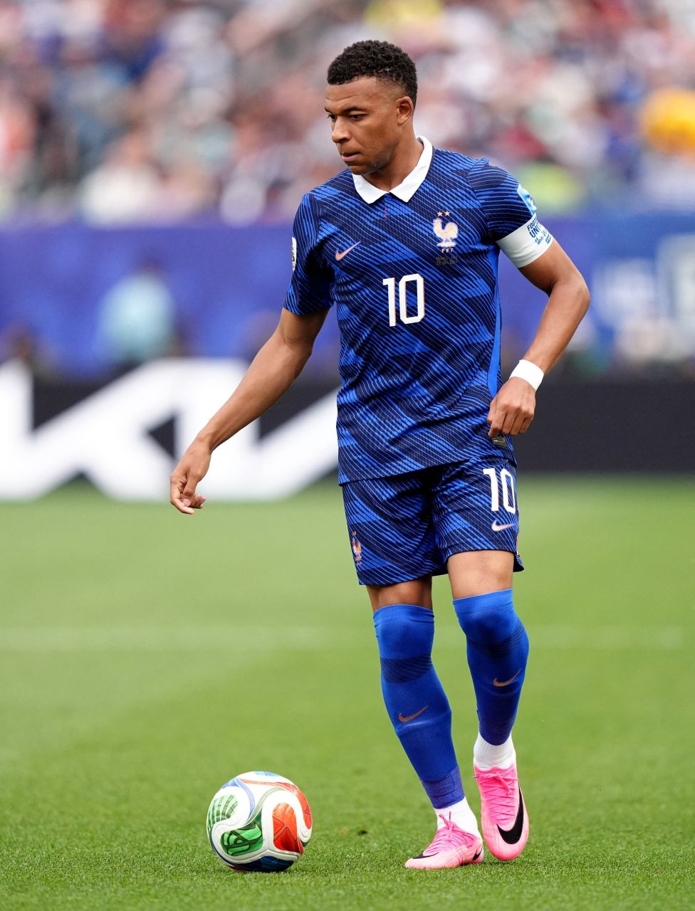 Kylian Mbappé finalizando de fora da área e comemorando o gol