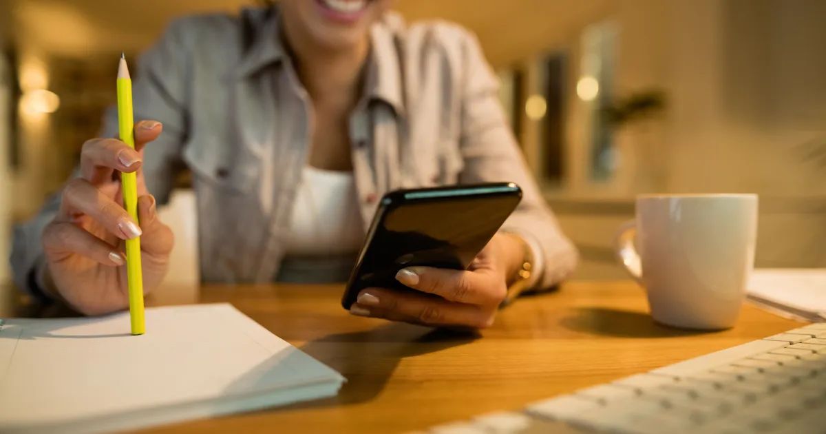 Pessoa conferindo aplicativo de investimentos no celular