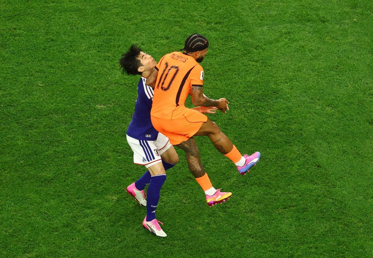 Memphis Depay disputa bola com Taniguchi no jogo Holanda x Japão