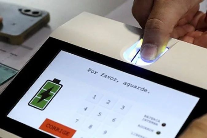Eleitor apresentando documento ao mesário na seção eleitoral