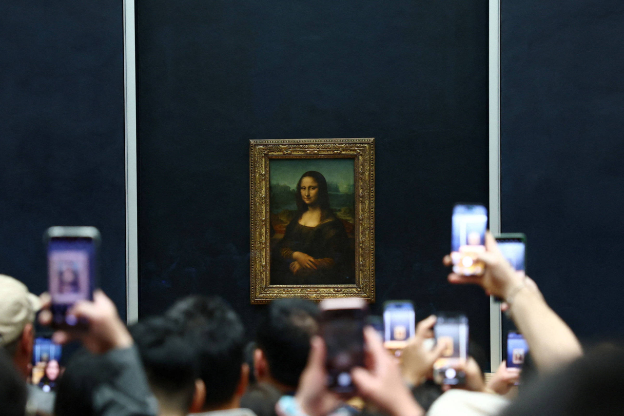 Visitantes se aglomeram diante da Mona Lisa no Louvre