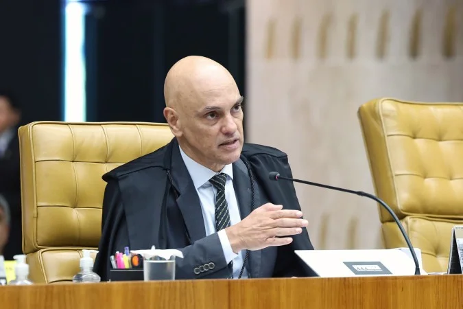 Ministro Alexandre de Moraes assinando decisão