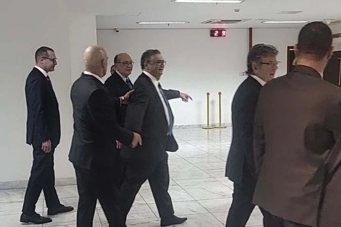 Ministro Alexandre de Moraes deixando o plenário do STF cercado por seguranças