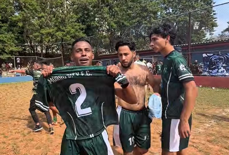 Jogadores do Morro City comemorando o título da Copa Urubuzão no campo de terra
