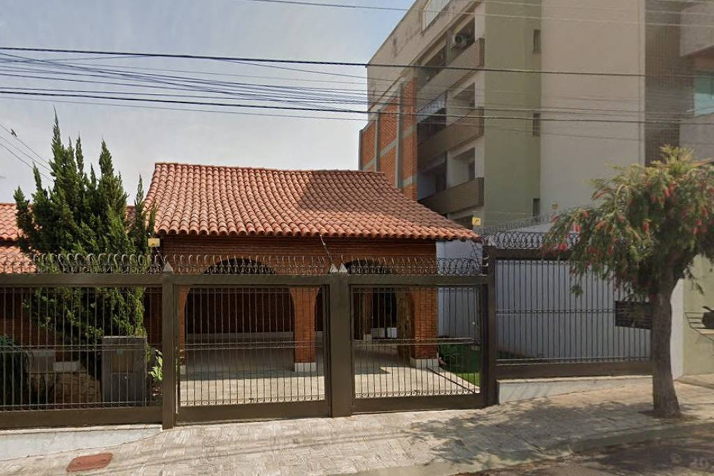 Muro alto separando casa e prédio em Passos, MG