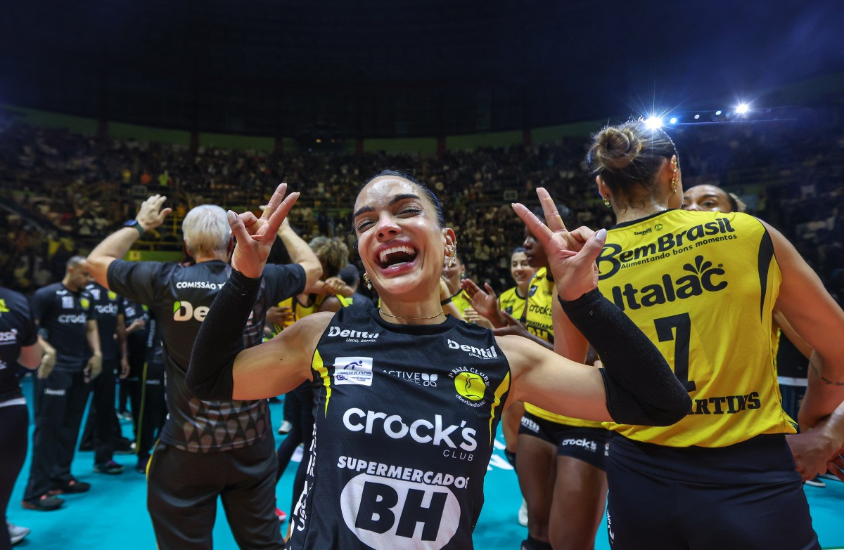 Natinha celebrando título da Superliga com troféu